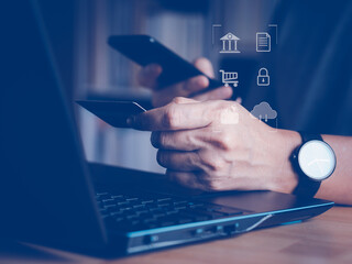 Online payment concept. Hand holding a credit card and using smart phone for online shopping and payment.