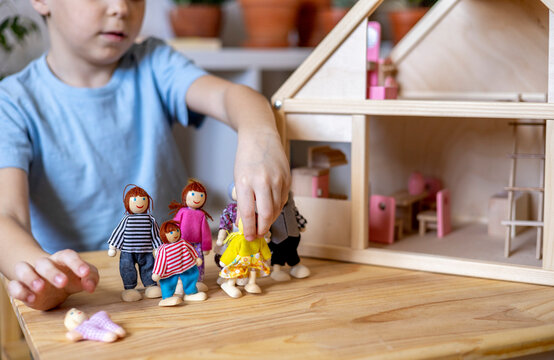 Montessori material. Toddler while playing with big pink dollhouse and having a great time.