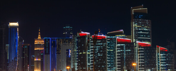 Night view of doha city skyline with many towers.