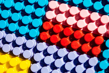 children's play background: the plane of plastic multi-colored bricks, blur, selective focus