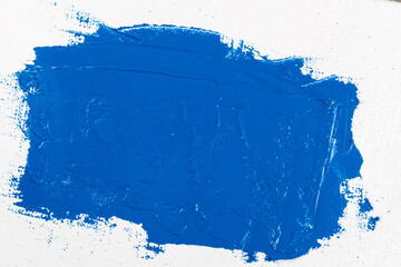 wide stroke of blue paint on a white artistic gauze of coarse weaving close-up, toning, free space