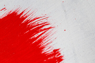 thick red bright acrylic paint applied unevenly on a light surface