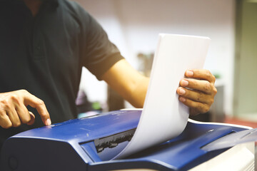 Technician hand press button and load paper in tray to using photocopier for scanning fax or photocopy or copy document after repairing paper jam or change toner cartridge in office workplace.
