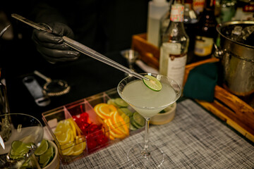 Barman making the daiquiri cocktail on the bar counter