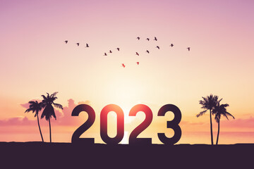 2023 number with palm tree on tropical sunset beach abstract background. Happy new year and holiday...