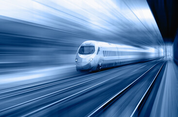 Blue high speed train runs on rail tracks - The train is going too fast as a result the air...