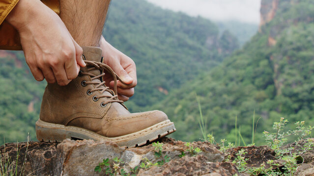 Hands of men tying shoe laces