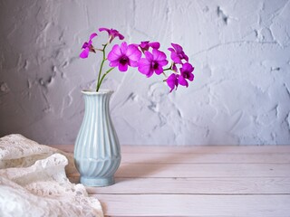 Purple flowers in vase on the table,Purple-pink flower orchids still life background or wallapper...