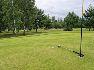 Obraz premium Golf game. Putter ball lies near hole on green closeup