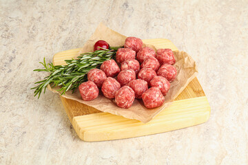 Raw uncooked beef meatballs served rosemary