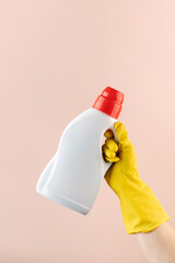A mockup of a bottle of laundry gel in a yellow rubber glove on a pink.