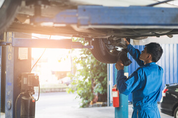 Auto check up and car service shop concept. Mechanic writing job checklist to clipboard to estimate repair quotation to client at workshop garage.