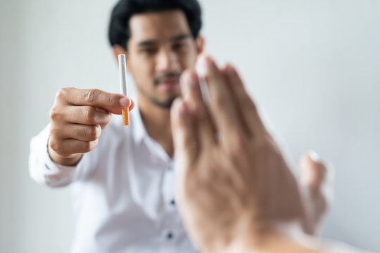 Close Up Hands Of Person Refusing To Smoke Cigarette.