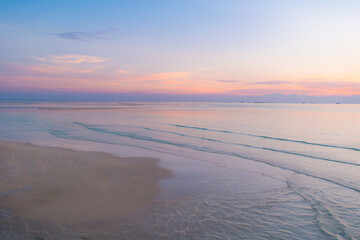 グラデーションの綺麗な夕焼けと海と浜　沈む太陽　癒しリラックスイメージ　地平線の背景素材