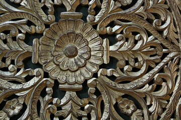 Decorative woodcraft - carved floral pattern on rustical furniture door, painted with gold color.