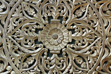 Vintage decorative floral pattern carved in wooden furniture door, painted with gentle gold colour