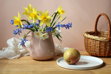 Obraz na płótnie Canvas spring flowers in a pink jug and an apple.