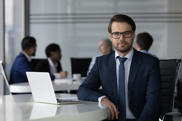 Confident serious business leader man in glasses corporate portrait with team of coworkers meeting...