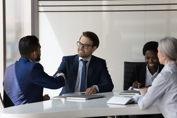 Happy confident business partners shaking hands on meeting. Businessman, company leaders expressing recognition to employed manager for good job, work achieve, giving handshake