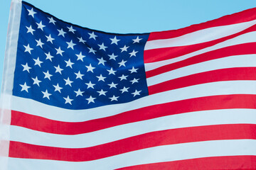 Fototapeta premium USA flag on a background of blue sky. National holidays concept