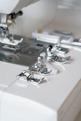 White modern ewing machine and its components close up. Sewing needle plate and replacement parts