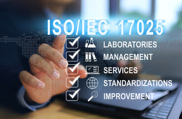 A businessman points a touch press to click activate ISO IEC 17025 on the workbench, which is the...