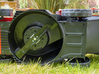 underside of a cordless lithium ion battery powered lawn mower exposing the rotary blade