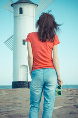 Woman with sunglasses in shape of heart on west breakwater. Windmill Stawa Mlyny in Swinoujscie. Summer and vacation time