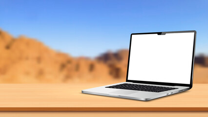 Laptop computer blank screen mockup on wooden table with empty space over blurred mountain view background