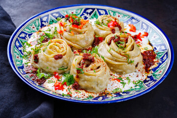 Traditional Afghan ay khanom steamed with mincemeat, paprika and yogurt as close-up on a classic...