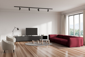 Light living room interior with couch and tv on drawer, armchair and panoramic window