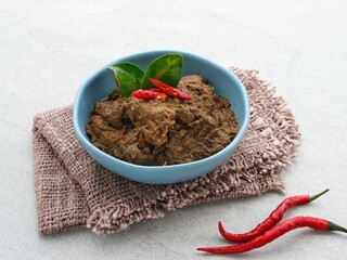 Rendang, Rendang Daging Sapi, Beef stew traditional food from Padang, Indonesia. The dish is arranged among the spices and herbs used in the original recipe like chili, lemongrass, onion, coconut milk