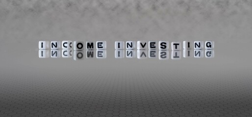income investing word or concept represented by black and white letter cubes on a grey horizon...