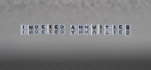 indexed annuities word or concept represented by black and white letter cubes on a grey horizon...
