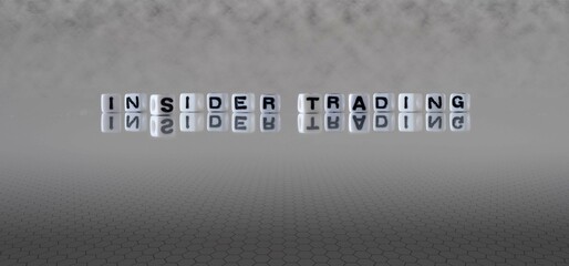 insider trading word or concept represented by black and white letter cubes on a grey horizon...