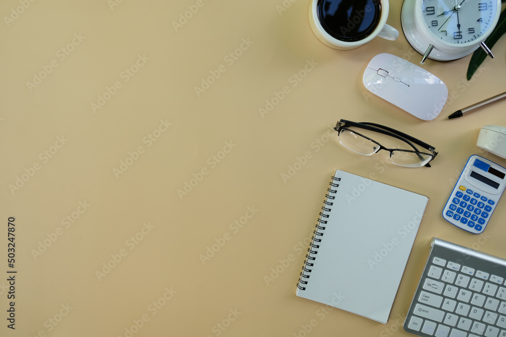 Poster blank notepad with a pen rests on an office desk table, surrounded by computer equipment and various