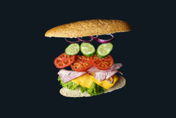 flying sandwich. Bread with ham, tomato, onion and lettuce. isolated on gray