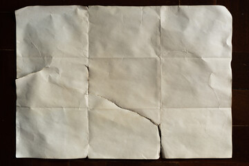 Old off white folded paper on dark wood background