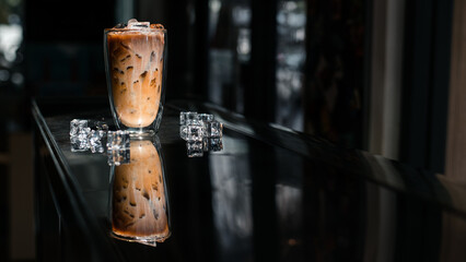 Close-up glass of iced coffee with milk on the table