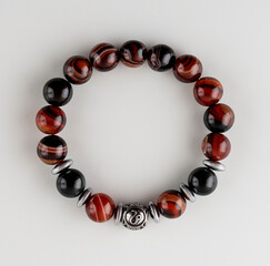 a bracelet made of round tiger eye stones. Perfectly polished to a shine with glare reflection. white background.