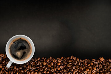 Cup of coffee with coffee beans on table