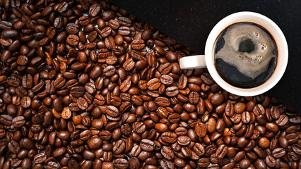 Cup of coffee with coffee beans on table
