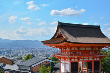 A torri of fire brick red sits silently toward an azure sky creating a special atmosphere with a small town