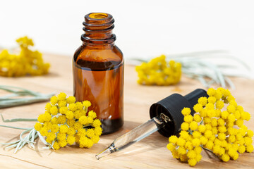 Helichrysum essential oil in amber bottle and pipette. Herbal remedies oil