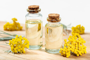 Helichrysum essential oil in glass bottle. Herbal remedies oil