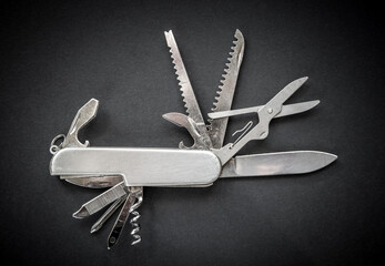 Metallic swiss knife isolated on black