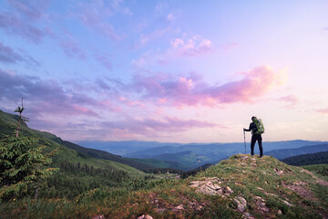 Active lifestyle. Traveling, hiking and trekking concept. Young woman with backpack in the Carpathian mountains on sunset.