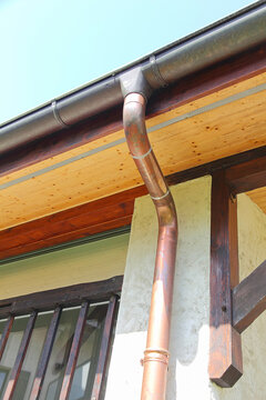 New bronze rain gutter system with drainpipe.