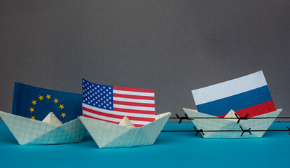 paper ship with national flag of Russia, united states of america and Europe union concept of sanctions and partnerships and free trade agreement, confrontation - obrazy, fototapety, plakaty