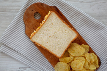 Homemade Pimento Cheese Sandwich with Chips on a rustic wooden board, top view. Flat lay, overhead, from above.